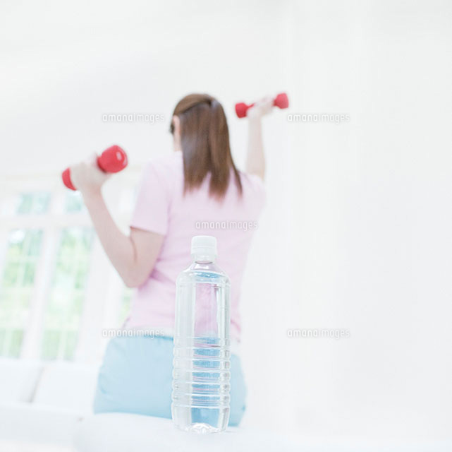 ダンベルを持つ女性の後ろ姿とペットボトルの水 の写真素材 イラスト素材 アマナイメージズ