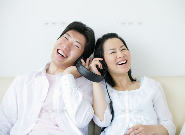 ソファで音楽を聴くカップル の写真素材 イラスト素材 アマナイメージズ