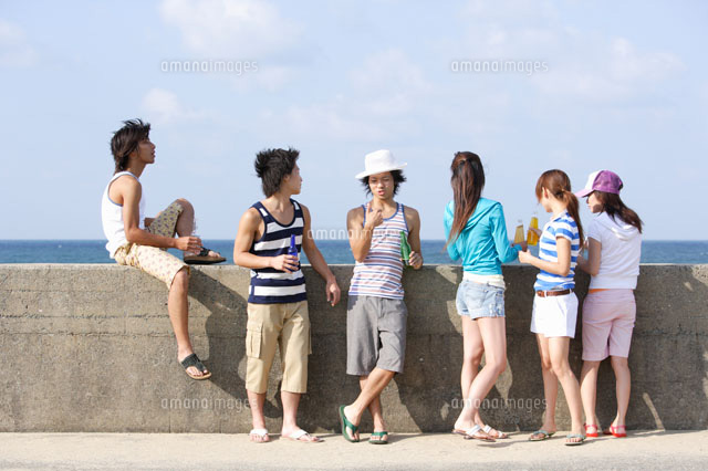 防波堤で寛ぐ若者達 の写真素材 イラスト素材 アマナイメージズ