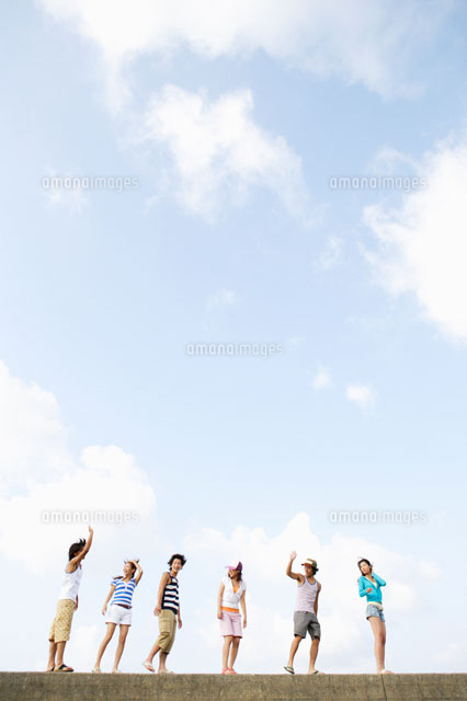 防波堤の上を歩く若者達 の写真素材 イラスト素材 アマナイメージズ