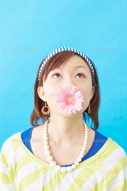 ガーベラの花をくわえる日本人女性 の写真素材 イラスト素材 アマナイメージズ