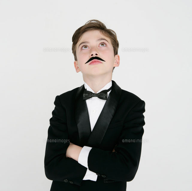 付け髭をするタキシードを着た男の子 の写真素材 イラスト素材 アマナイメージズ