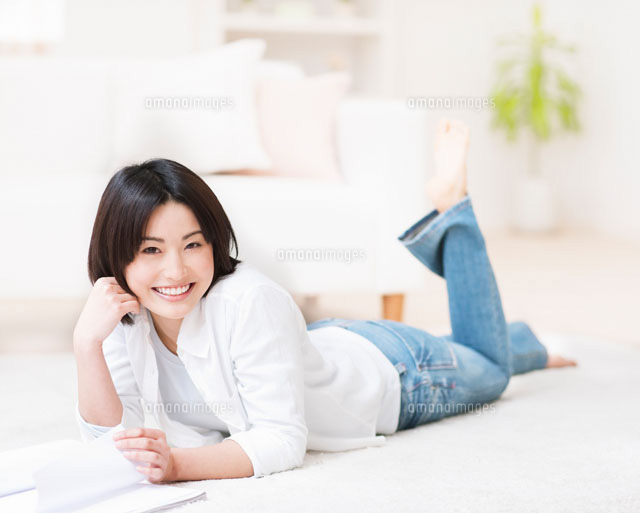 寝転んで頬杖をつく女性 の写真素材 イラスト素材 アマナイメージズ