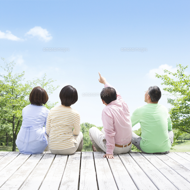ウッドデッキに座る日本人男女達の後ろ姿 の写真素材 イラスト素材 アマナイメージズ