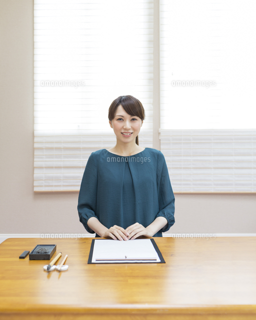 習字道具が置かれた机に向かう女性 の写真素材 イラスト素材 アマナイメージズ
