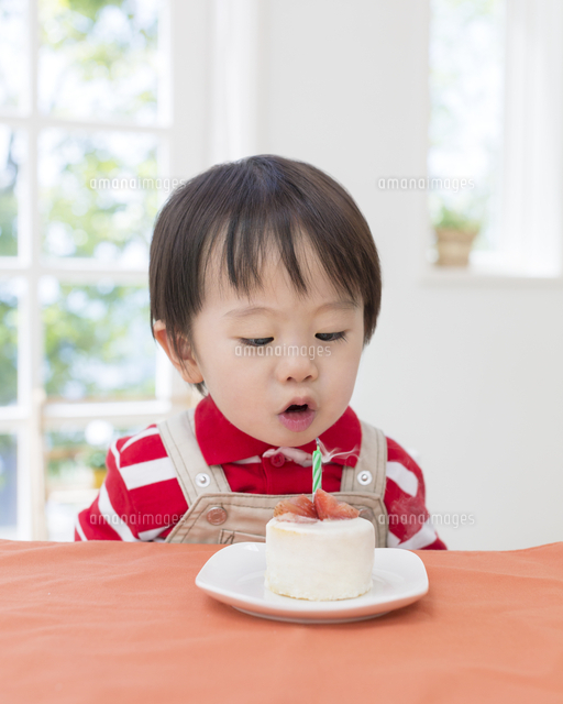 ケーキのろうそくに息を吹く男の子 の写真素材 イラスト素材 アマナイメージズ