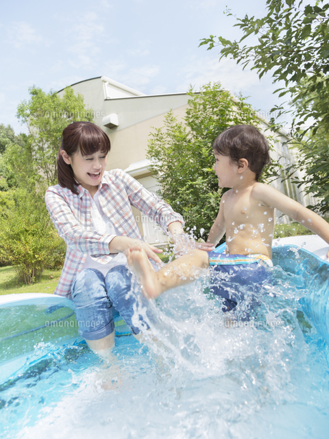 プールで水遊びする親子 の写真素材 イラスト素材 アマナイメージズ