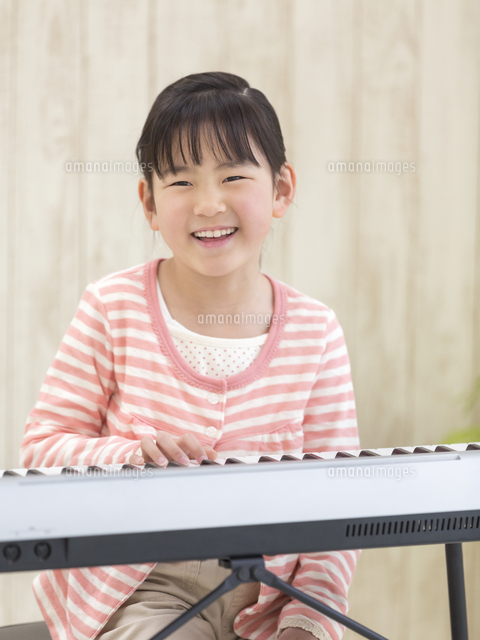 電子ピアノを弾く女の子 の写真素材 イラスト素材 アマナイメージズ