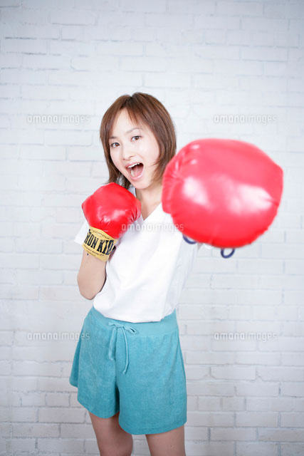 ボクシンググローブをつけてパンチをする女性 の写真素材 イラスト素材 アマナイメージズ