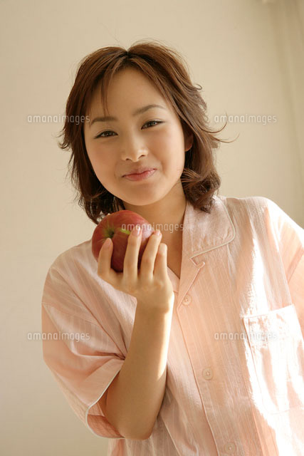 りんごを持つパジャマを着た女性 の写真素材 イラスト素材 アマナイメージズ