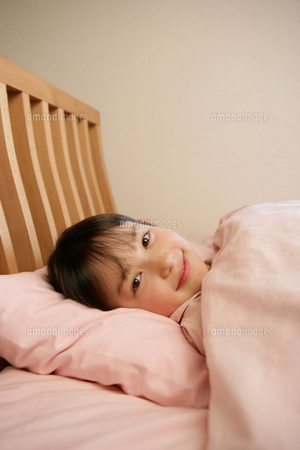 ベッドに横たわる女の子 の写真素材 イラスト素材 アマナイメージズ