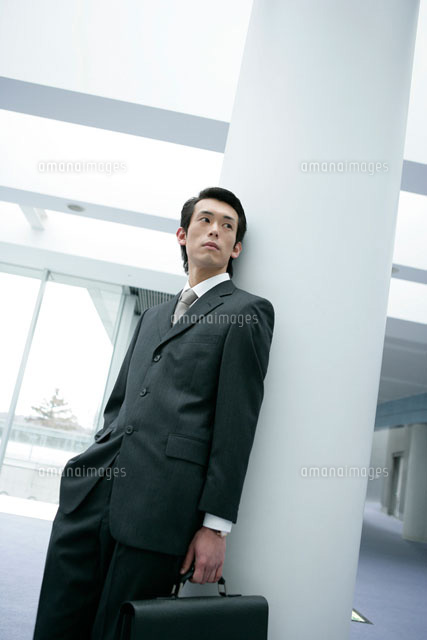 柱に寄りかかる男性 の写真素材 イラスト素材 アマナイメージズ