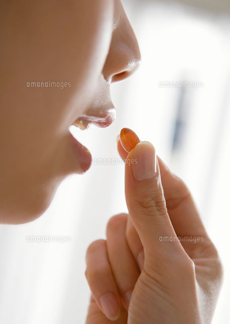 サプリメントを飲む女性 の写真素材 イラスト素材 アマナイメージズ
