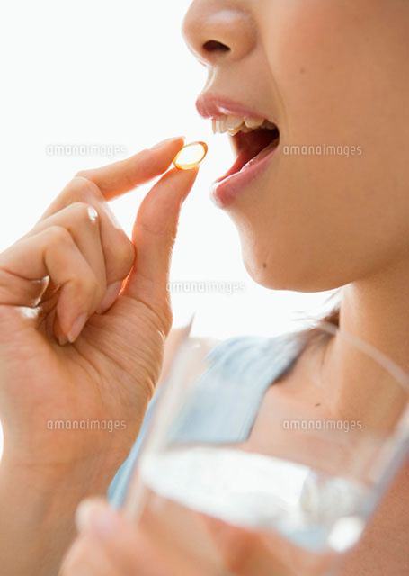 サプリメントを飲む女性 の写真素材 イラスト素材 アマナイメージズ