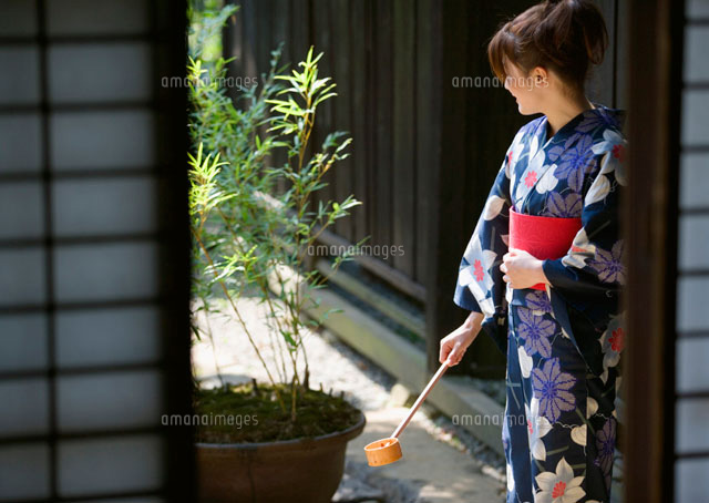 打ち水をする浴衣姿の女性 の写真素材 イラスト素材 アマナイメージズ