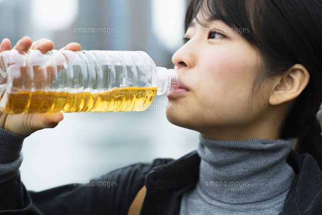 ペットボトルの麦茶を飲む女性 の写真素材 イラスト素材 アマナイメージズ