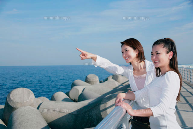海辺で微笑む女性の写真 海を眺める女性2人[11014007021]の写真・イラスト素材｜アマナイメージズ
