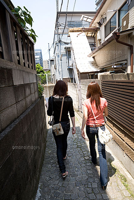 路地を歩く女性二人 の写真素材 イラスト素材 アマナイメージズ