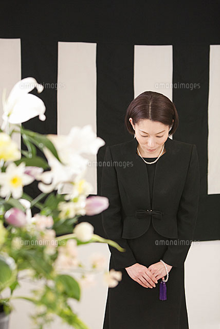 鯨幕の前でお辞儀をする喪服姿の女性と花束 の写真素材 イラスト素材 アマナイメージズ