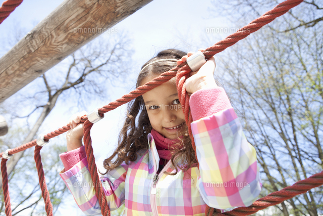 Girl climbing ropes in playground[11015225860]の写真素材・イラスト素材｜アマナイメージズ