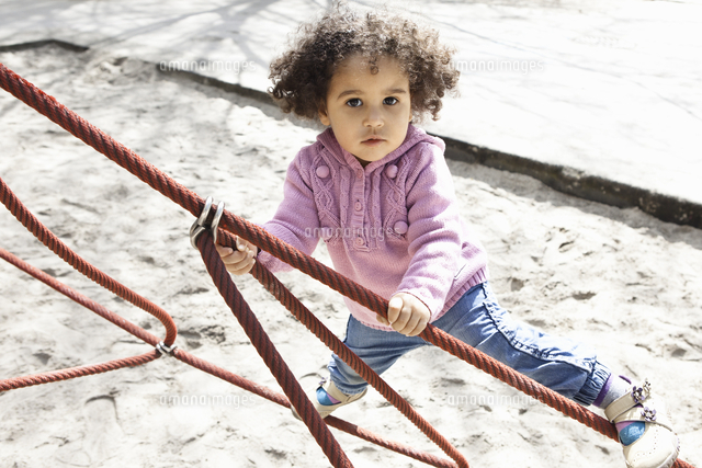 Girl climbing ropes in playground[11015225864]の写真素材・イラスト素材｜アマナイメージズ