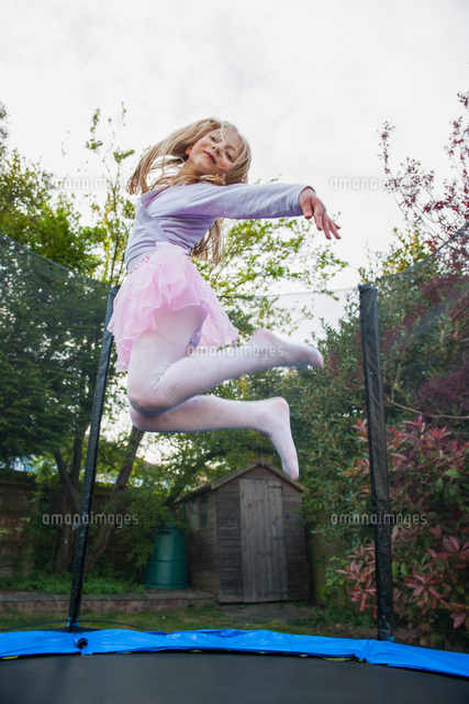 Girl Bouncing On Trampoline Wearing Tutu の写真素材 イラスト素材 アマナイメージズ