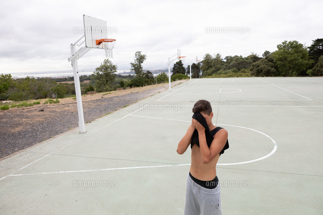 Male Teenage Basketball Player Wiping His Brow With Vest On Basketball Court の写真素材 イラスト素材 アマナイメージズ