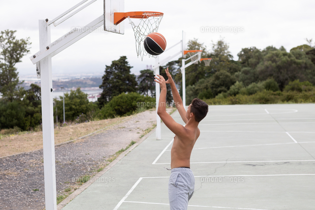 Male Teenage Basketball Player Throwing Ball Toward Basketball Hoop の写真素材 イラスト素材 アマナイメージズ