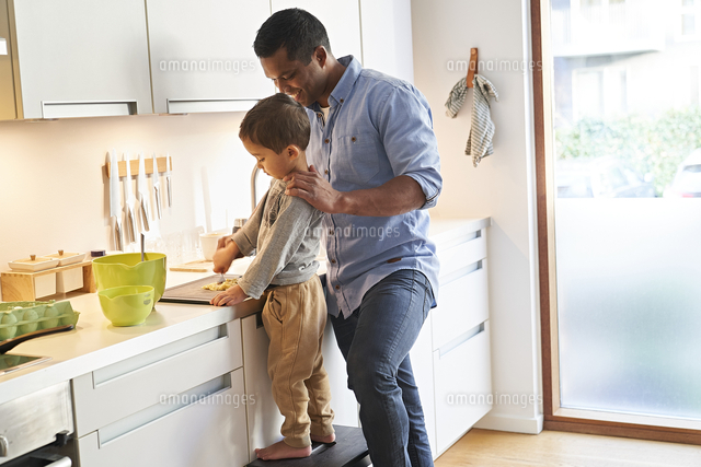 A Father And Son Both Standing At A Kitchen Worktop Preparing Food On A Chopping Board の写真素材 イラスト素材 アマナイメージズ
