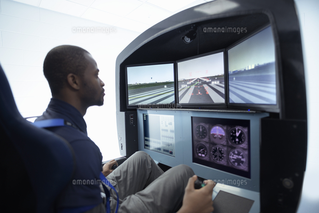 A student sitting in a flight simulator looking at the screens ...