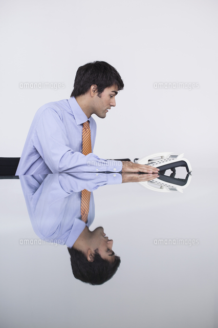 Businessman Talking On Conference Telephone In Conference Room の写真素材 イラスト素材 アマナイメージズ