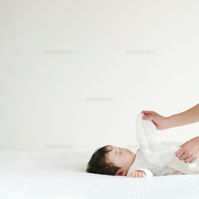 赤ちゃんに毛布をかける母親の手元 の写真素材 イラスト素材 アマナイメージズ