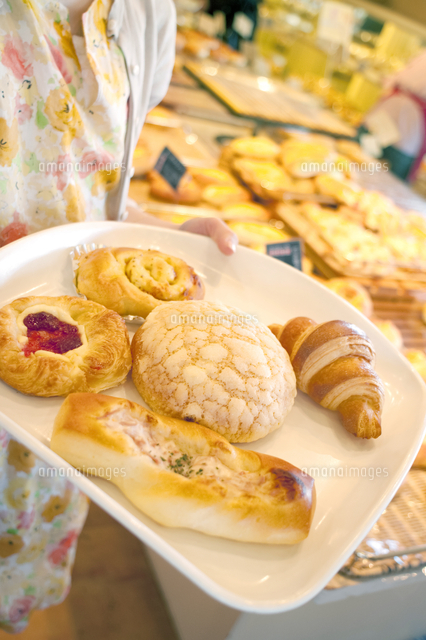 パン屋でトレイに取ったパン の写真素材 イラスト素材 アマナイメージズ