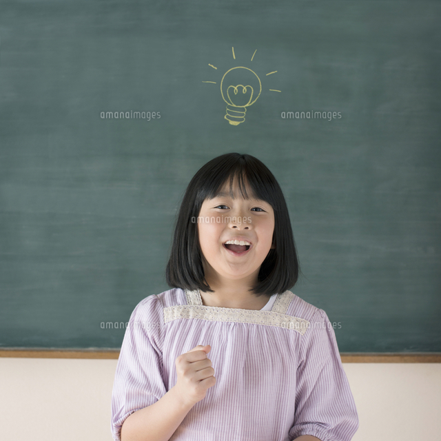 黒板の前でひらめいたポーズをする女の子 の写真素材 イラスト素材 アマナイメージズ