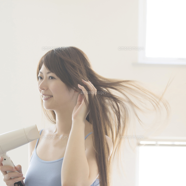 ドライヤーで髪を乾かす女性 の写真素材 イラスト素材 アマナイメージズ