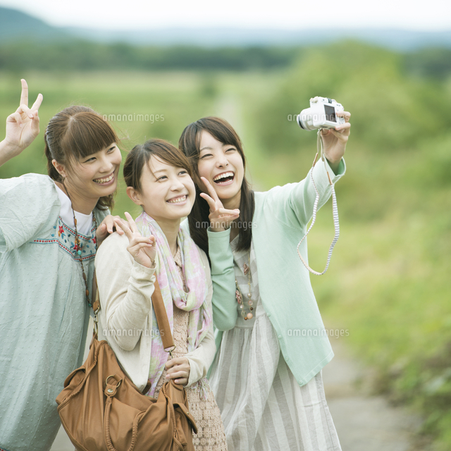 カメラで写真を撮る3人の女性 の写真素材 イラスト素材 アマナイメージズ