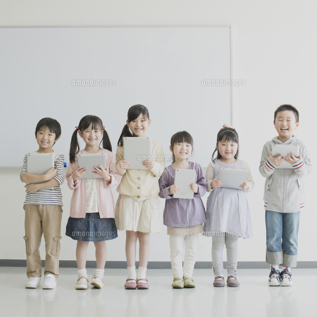 タブレットpcを持ち微笑む小学生 の写真素材 イラスト素材 アマナイメージズ