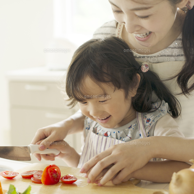母親に野菜の切り方を教えてもらう女の子 の写真素材 イラスト素材 アマナイメージズ