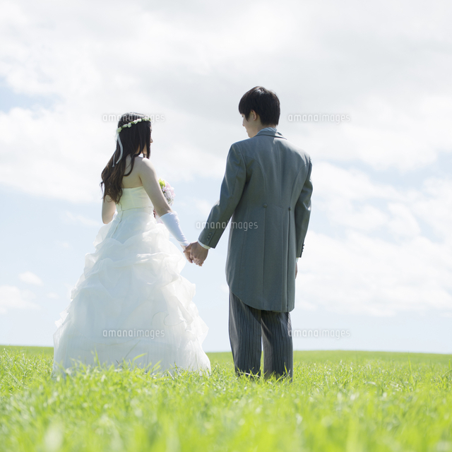 草原で手をつなぐ新郎新婦の後姿 の写真素材 イラスト素材 アマナイメージズ