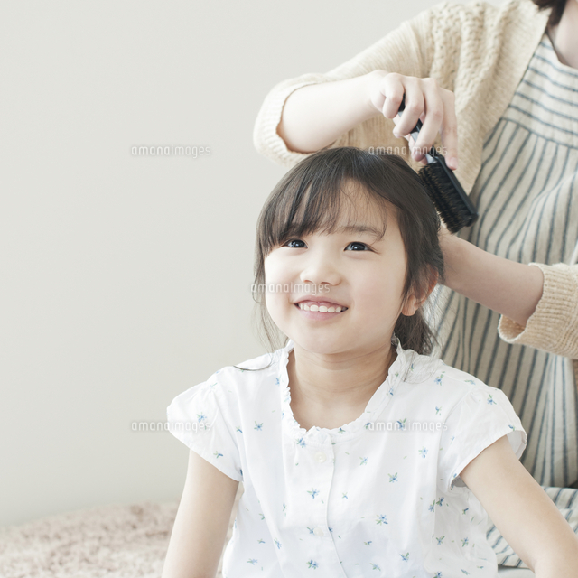 母親に髪を結んでもらう女の子 の写真素材 イラスト素材 アマナイメージズ