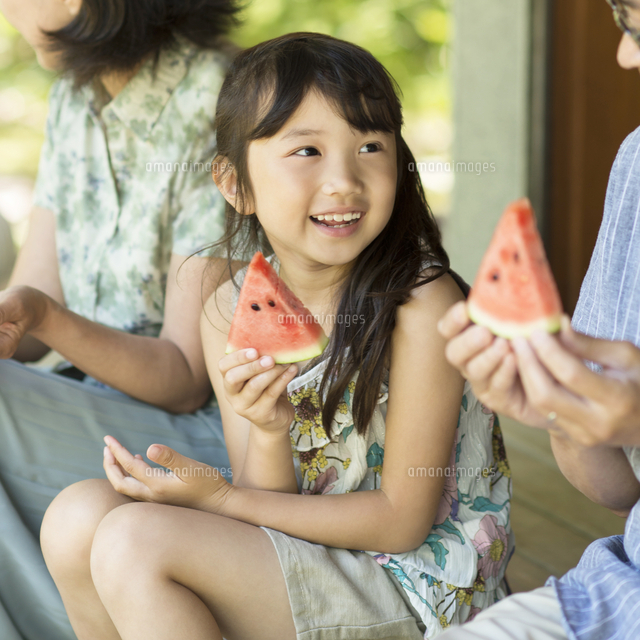 縁側でスイカを食べる女の子 の写真素材 イラスト素材 アマナイメージズ