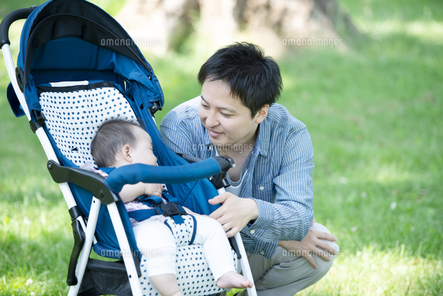 ベビーカーに乗る赤ちゃんの様子を見る父親 の写真素材 イラスト素材 アマナイメージズ