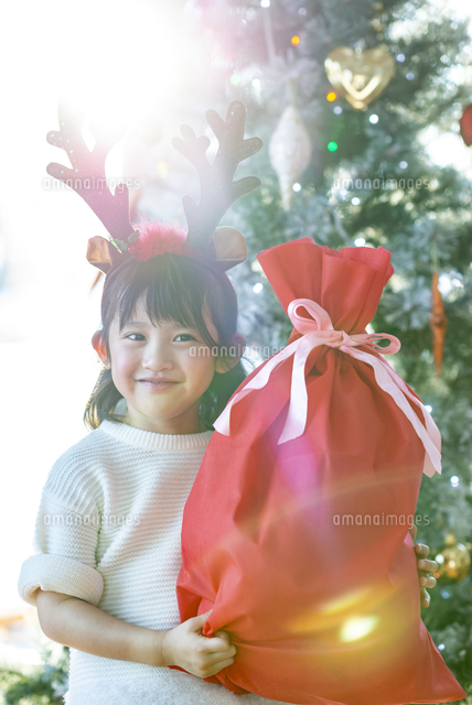 クリスマスプレゼントを持ち微笑む女の子 の写真素材 イラスト素材 アマナイメージズ クリスマスプレゼントを持ち微笑む女の子 の写真素材 イラスト素材 アマナイメージズ