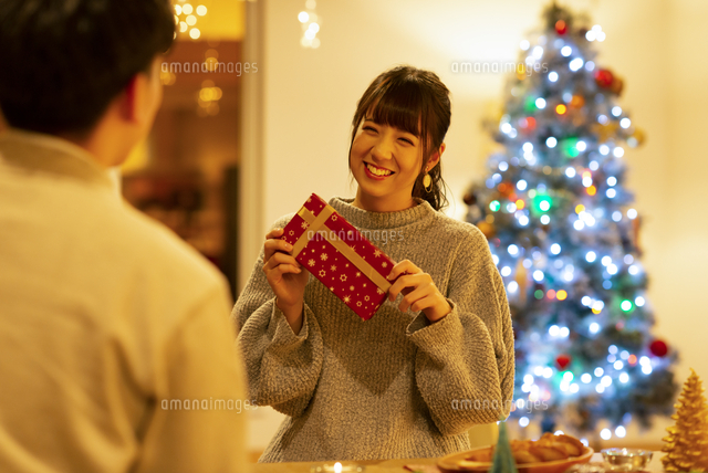 クリスマスプレゼントを渡すカップル の写真素材 イラスト素材 アマナイメージズ