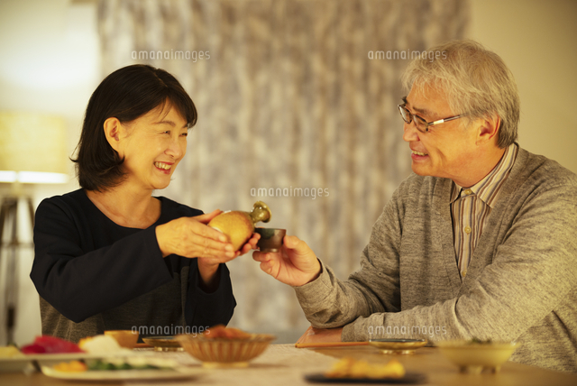 日本酒で晩酌をするシニア夫婦 の写真素材 イラスト素材 アマナイメージズ