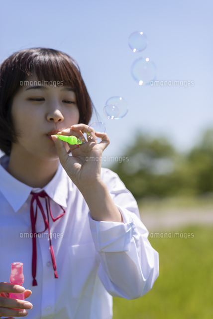 シャボン玉を吹く女子学生 の写真素材 イラスト素材 アマナイメージズ