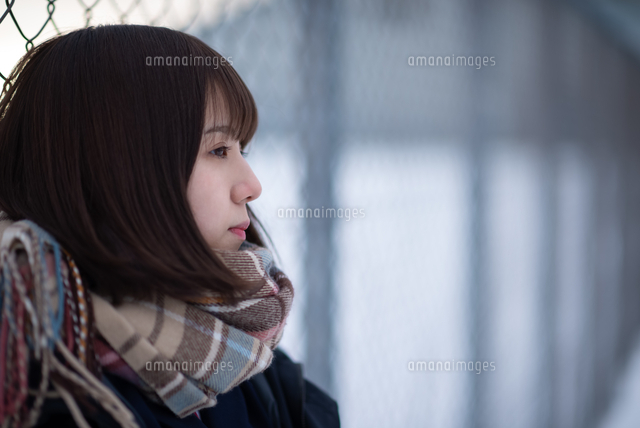 フェンスに寄りかかる女子学生 の写真素材 イラスト素材 アマナイメージズ