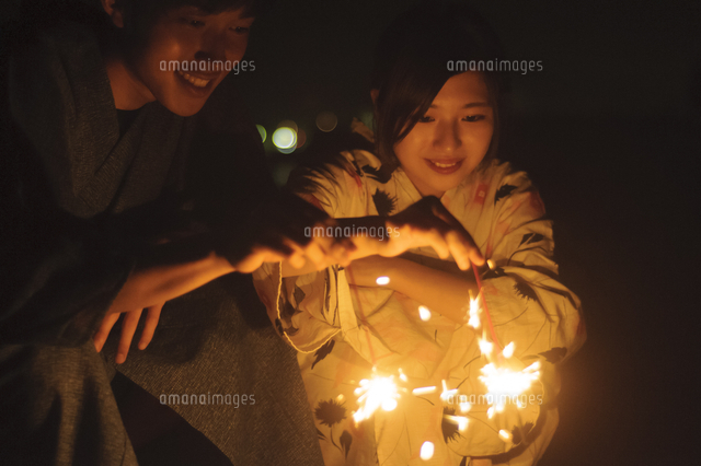 花火をする浴衣姿のカップル の写真素材 イラスト素材 アマナイメージズ