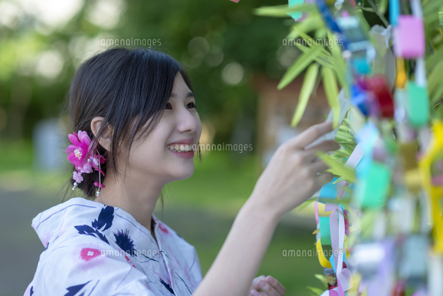 七夕の飾りを見る浴衣姿の女性 の写真素材 イラスト素材 アマナイメージズ