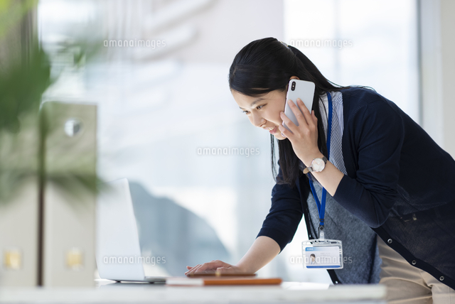 デスクで電話応対をするビジネスウーマン の写真素材 イラスト素材 アマナイメージズ